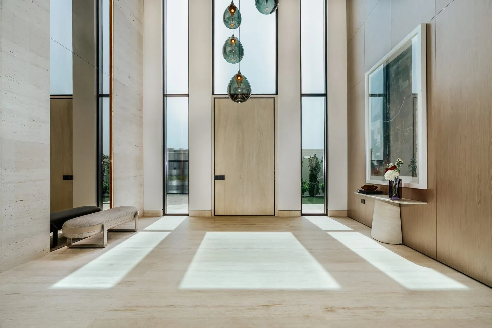 Entrance with tall windows and travertine at Villa Cielo